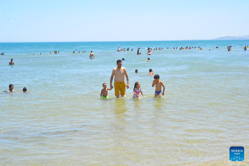 People cool off by seaside during heat wave in Tunis