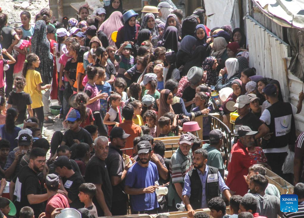 People gather to receive food relief in Jabalia refugee camp in Gaza Strip