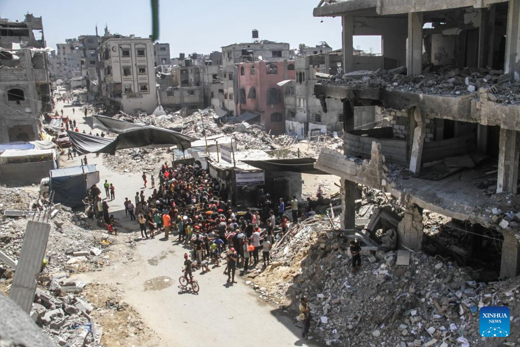 People gather to receive food relief in Jabalia refugee camp in Gaza Strip