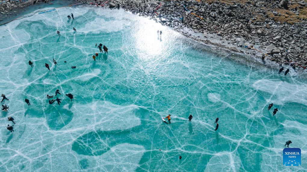 Tourists have fun on icy lake in Lhasa, China's Xizang