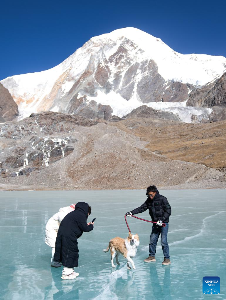 Tourists have fun on icy lake in Lhasa, China's Xizang