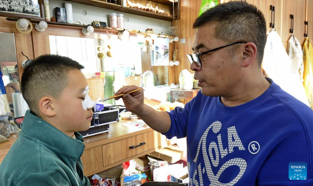 Intangible cultural heritage inheritor promotes Peking Opera facial makeup painting