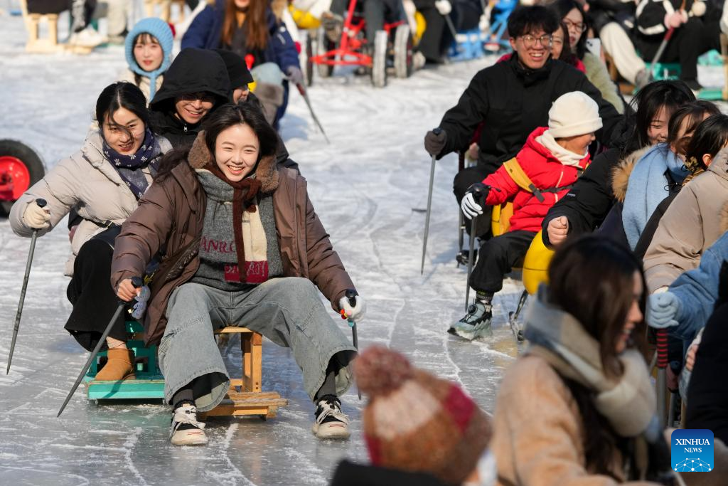 People have fun on ice rink at Tuanjiehu Park in Beijing