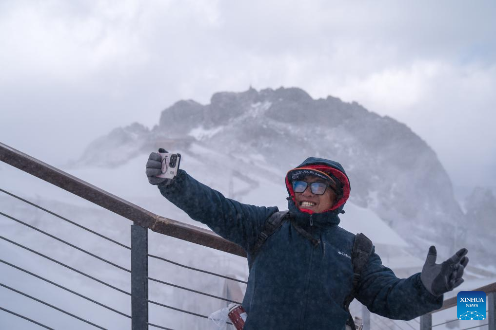 Picturesque snowy scene on snow mountain attracts tourists in SW China