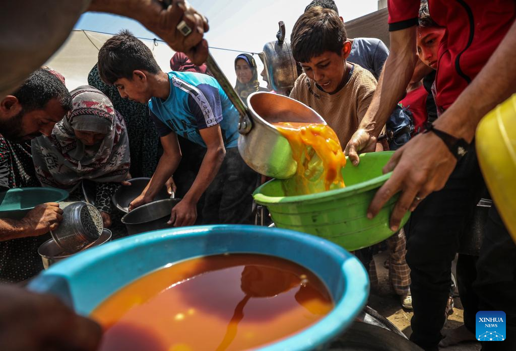 Palestinians receive free food at food distribution center in Gaza City