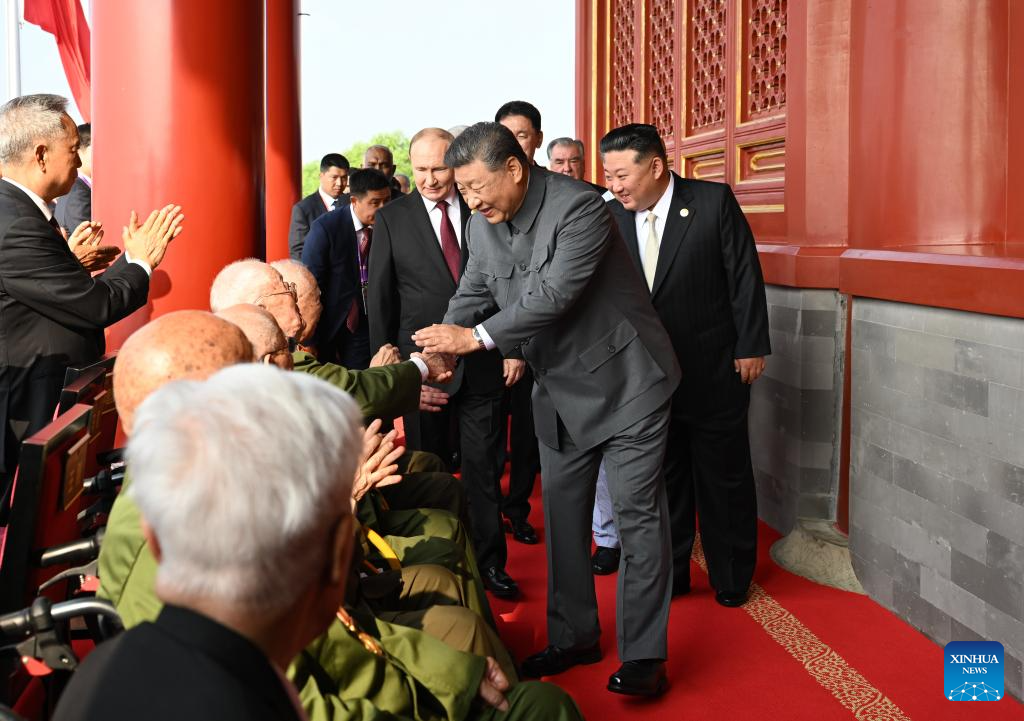 Xi ascends Tian'anmen Rostrum, greets war veterans