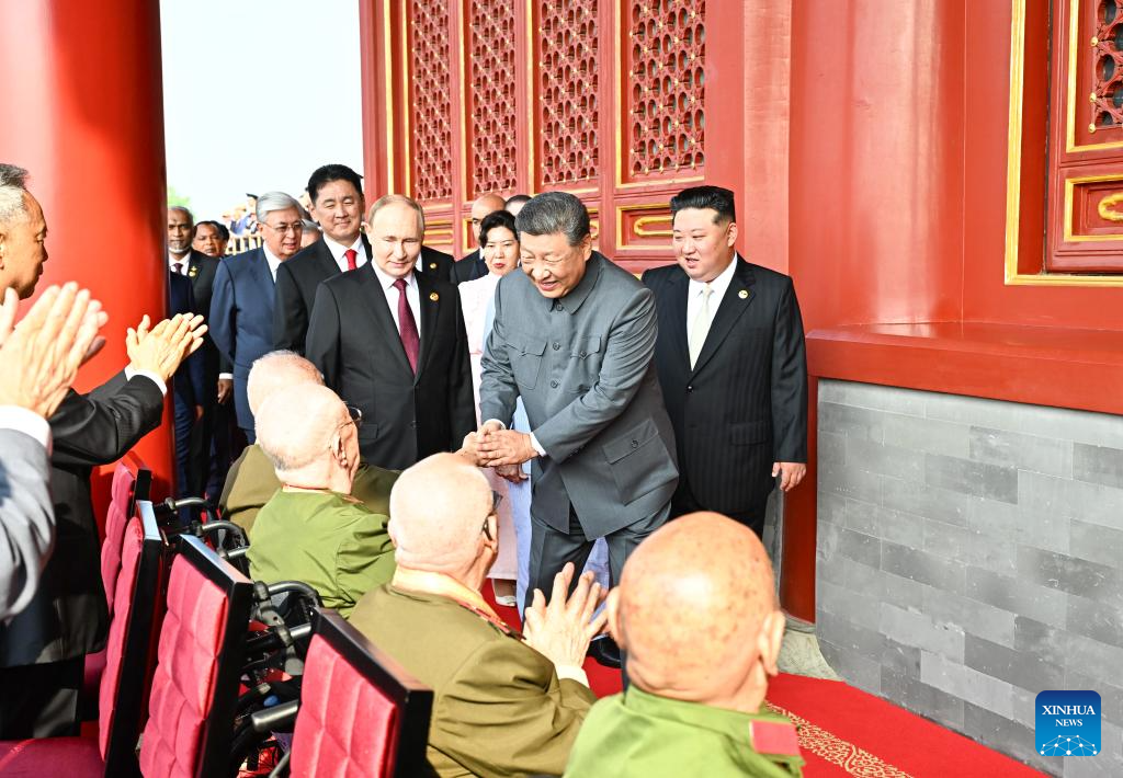 Xi ascends Tian'anmen Rostrum, greets war veterans