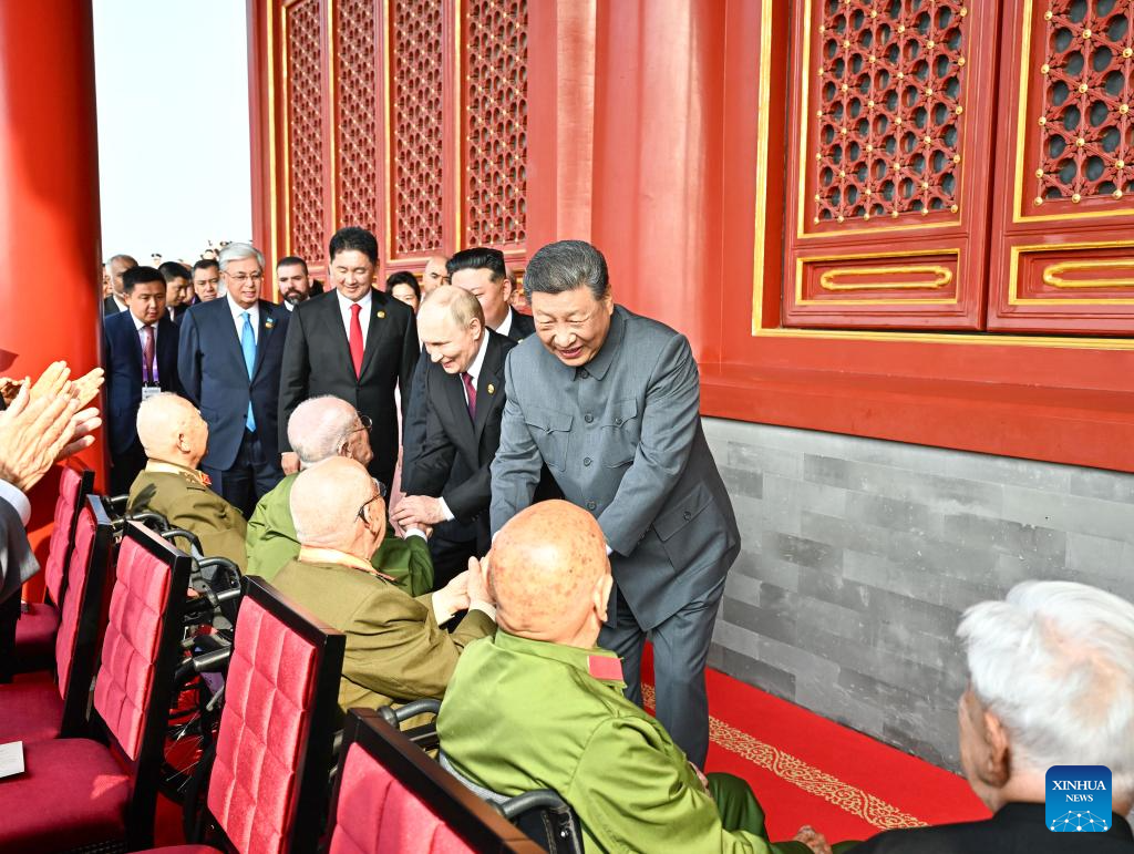 Xi ascends Tian'anmen Rostrum, greets war veterans