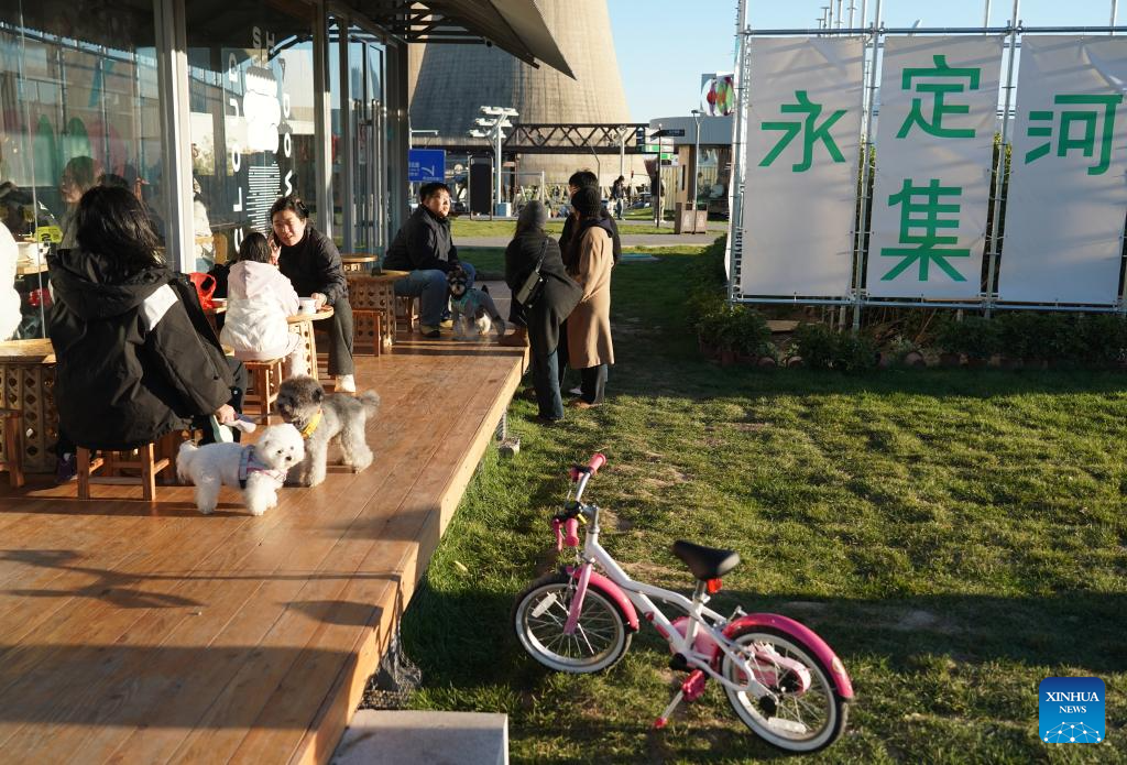 People enjoy leisure time by Yongding River in Beijing