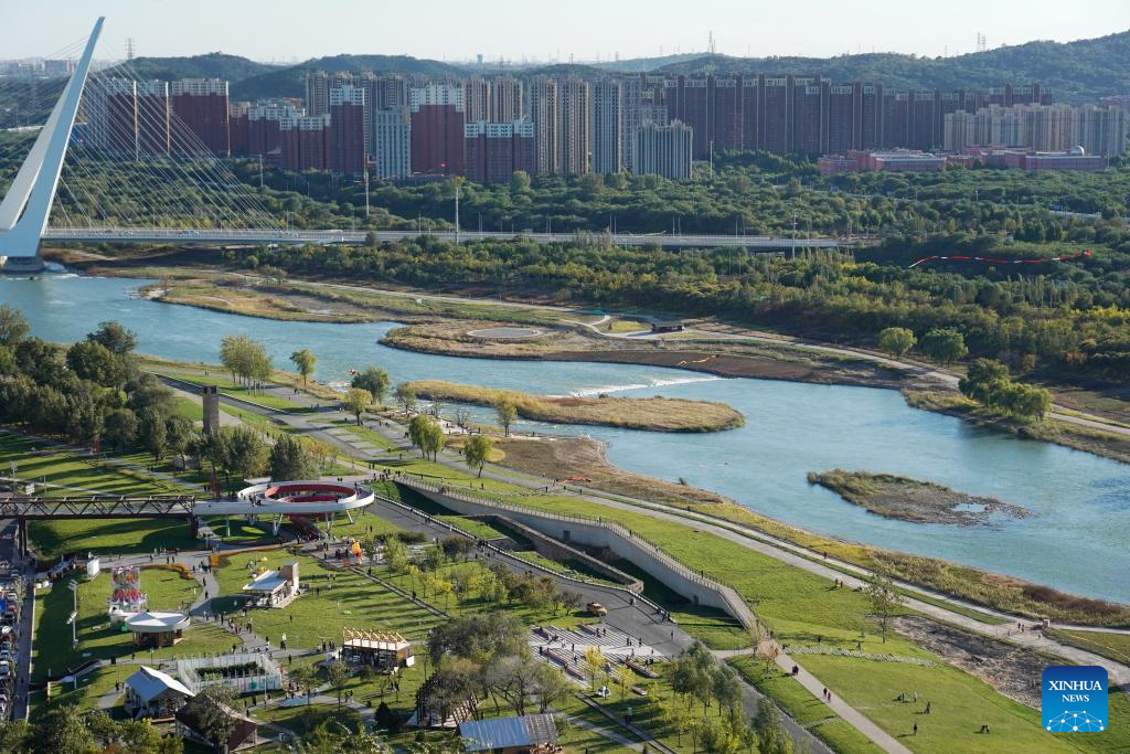 People enjoy leisure time by Yongding River in Beijing
