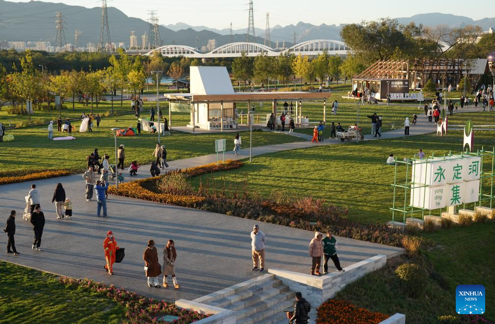 People enjoy leisure time by Yongding River in Beijing