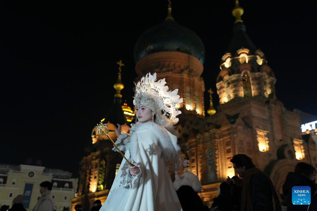 Tourists take travel photos at square of architecture art in Harbin
