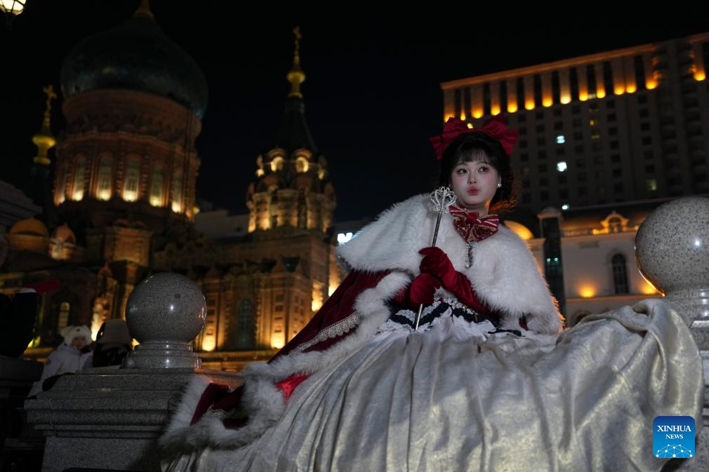Tourists take travel photos at square of architecture art in Harbin