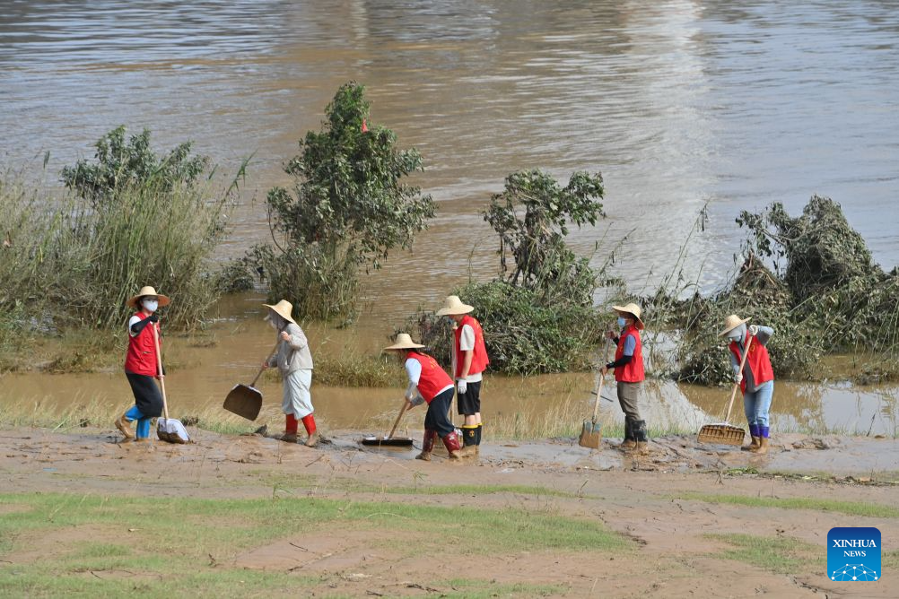 People clear mud after flooding at park in Guangxi, S China