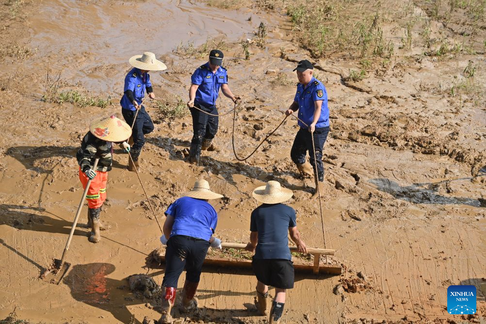 People clear mud after flooding at park in Guangxi, S China