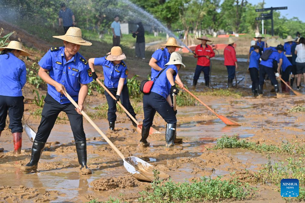 People clear mud after flooding at park in Guangxi, S China