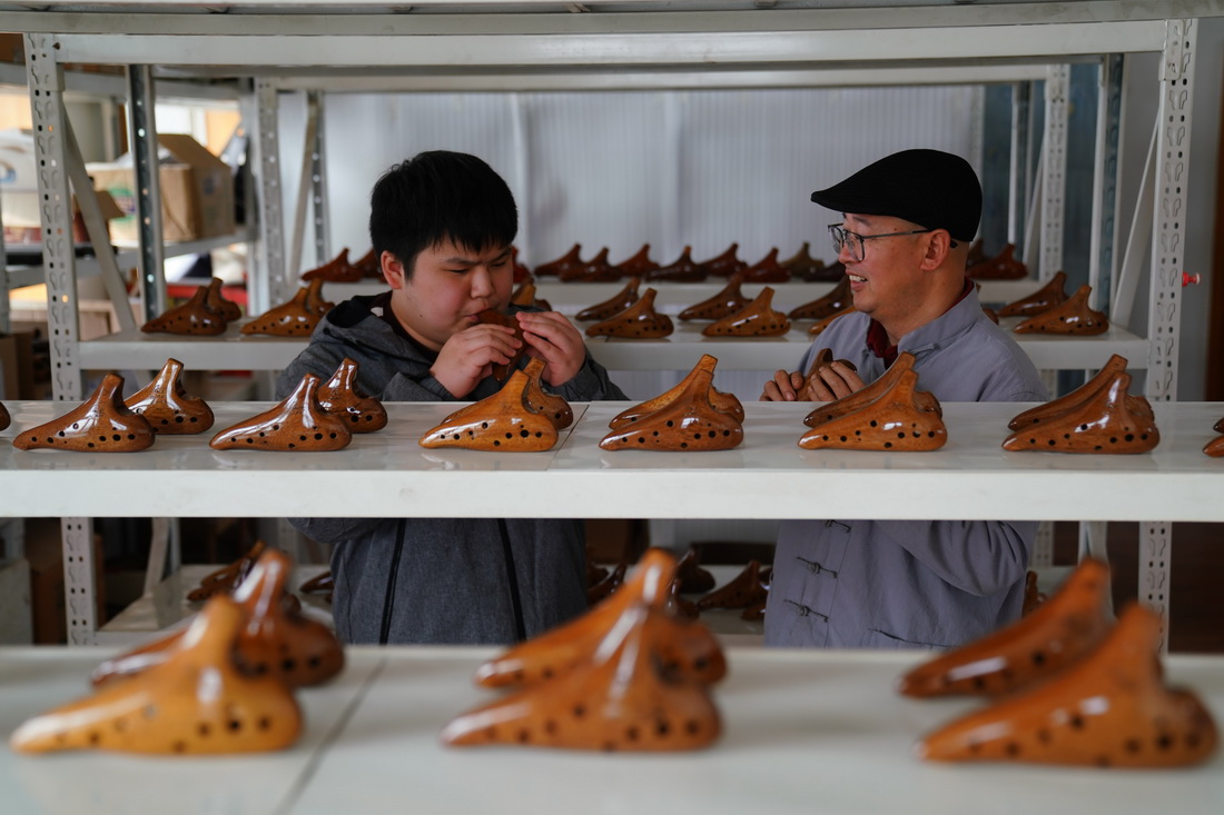 2月20日，陶笛艺人侯义敏（右）和学生李鑫为木质陶笛试音。